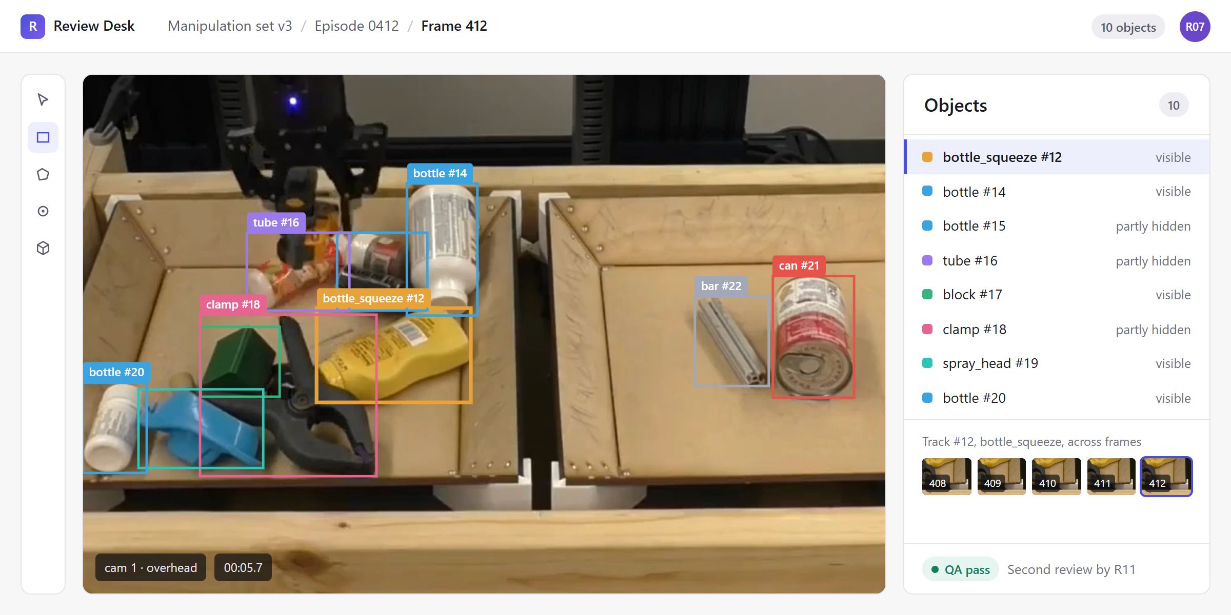 Frame 412 in our labelling workspace: ten objects boxed on the robot trays, each with a class and track ID such as bottle_squeeze #12, can #21 and clamp #18, occlusion marked visible or partly hidden, and track #12 followed across frames 408 to 412.